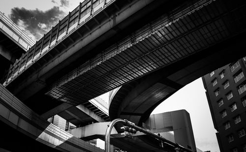 Low angle view of elevated walkway against buildings in city