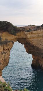 Rock formations by sea against sky