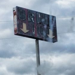 Low angle view of road sign against sky