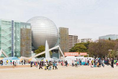 Group of people in city against sky