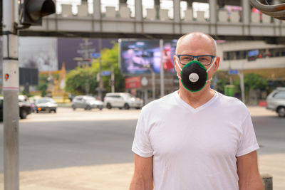 Portrait of man standing on street in city