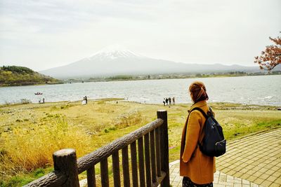 Rear view of woman looking at sea against sky