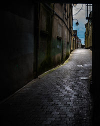 Empty narrow alley along buildings