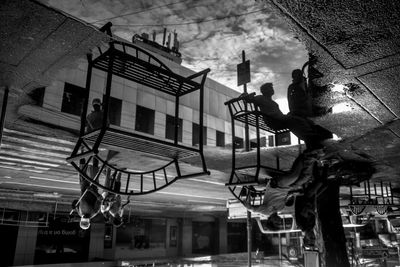 People on staircase in city against sky