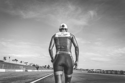 Rear view of a man walking on road