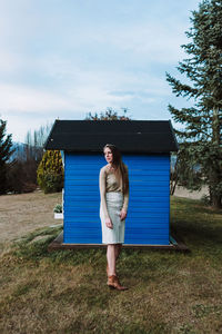 Portrait of woman standing on field against sky