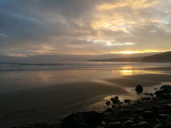 Scenic view of beach against sky during sunset