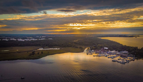 High angle view of city by sea against sky during sunset