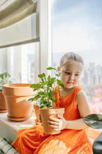 Cute girl sitting by window