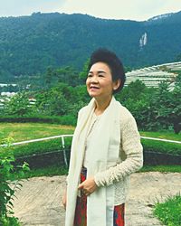 Beautiful young woman standing on mountain against clear sky