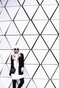 Glamorous blonde standing at the wall. urban fashion style