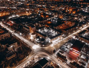 High angle view of illuminated street amidst buildings in city at night