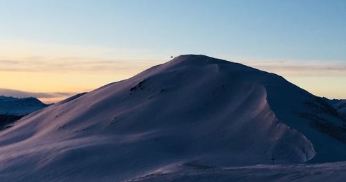Scenic view of snowcapped mountains against sky during sunset