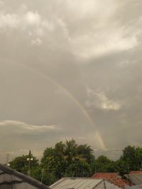 Scenic view of rainbow over buildings against sky