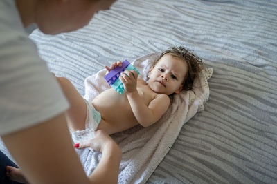 High angle view of young woman sitting on bed at home