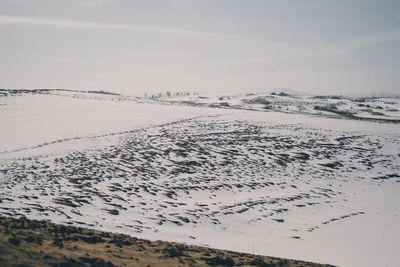 Scenic view of snow covered land against sky