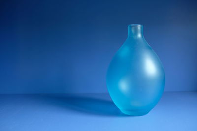 Close-up of blue glass bottle on table