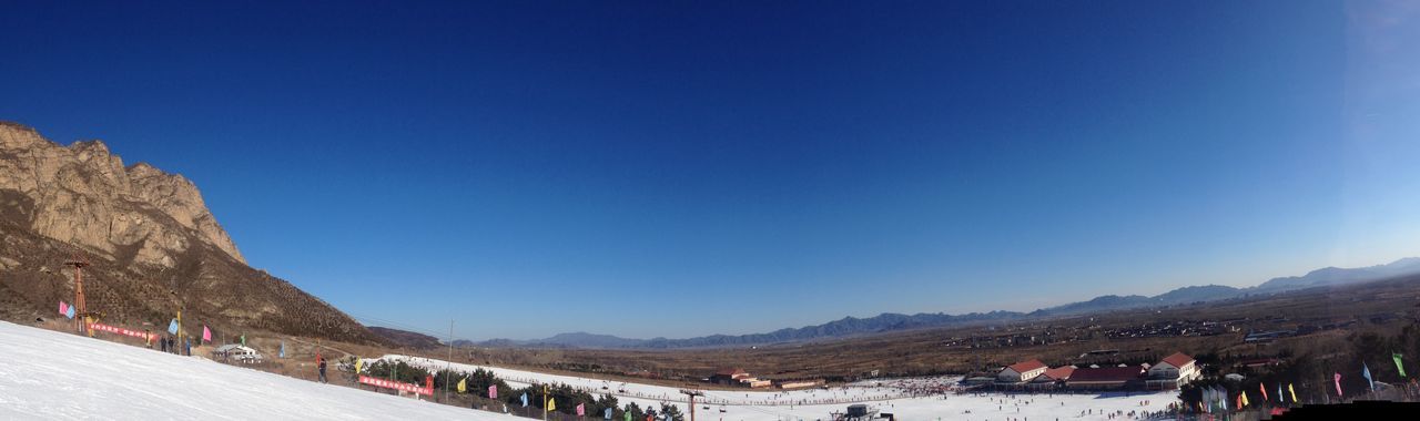 clear sky, copy space, mountain, blue, mountain range, built structure, architecture, building exterior, scenics, large group of people, tourism, travel destinations, tranquility, tourist, incidental people, beauty in nature, nature, outdoors, tranquil scene, vacations