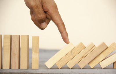 Close-up of man holding hands against white background