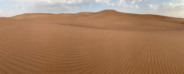 Scenic view of sand dunes in desert against sky