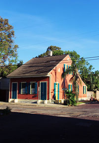 Houses by street against blue sky
