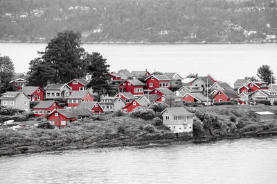 Houses by sea against sky during winter