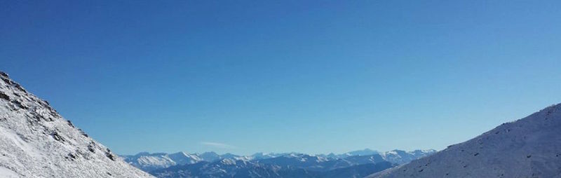 Scenic view of mountains against clear blue sky