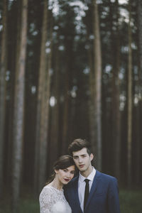Portrait of wedding couple standing in forest