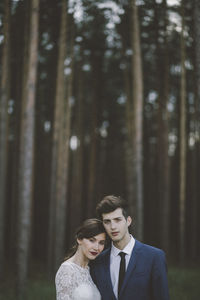 Portrait of wedding couple standing in forest