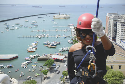 A woman dressed as a hero with a protective helmet holding the rappel rope.