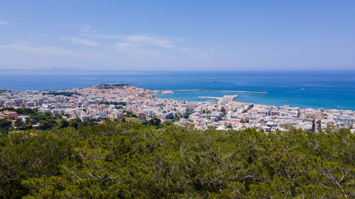 High angle view of townscape by sea against sky