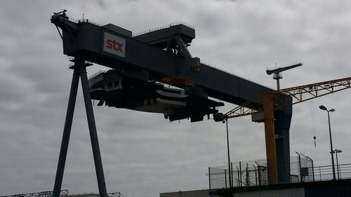 Low angle view of crane against sky