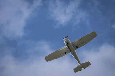 Low angle view of airplane flying against sky