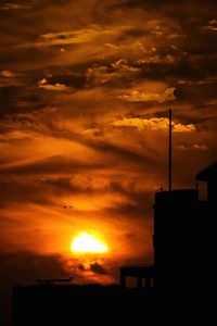 Low angle view of silhouette buildings against sky during sunset