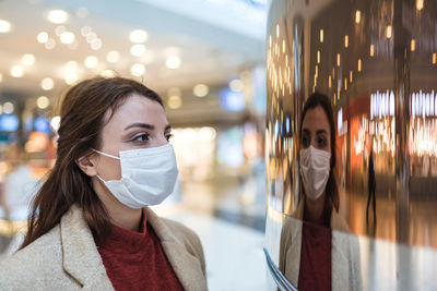 Portrait of young woman with reflection on mirror