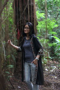 Young woman standing in forest