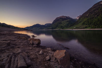 Scenic view of lake and mountains against clear sky