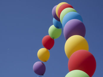 Low angle view of balloons against blue sky