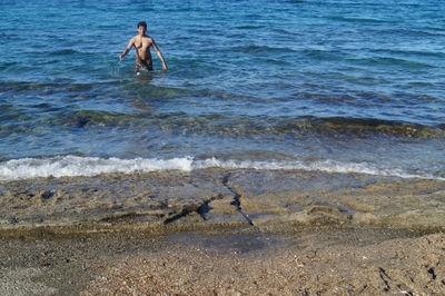 High angle view of shirtless man in sea at beach