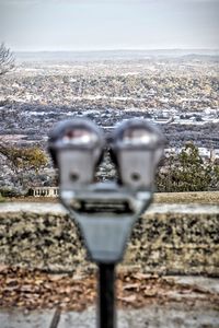 Close-up of coin-operated binoculars against sea