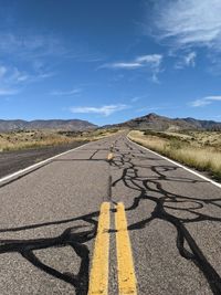 Road leading towards mountain against sky