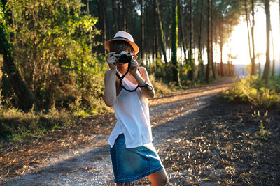 Full length of man standing on road in forest