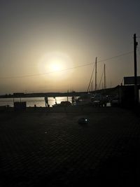 Silhouette boats in calm sea at sunset