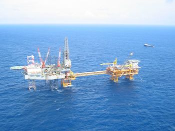 Scenic view of oil drill in sea against clear sky