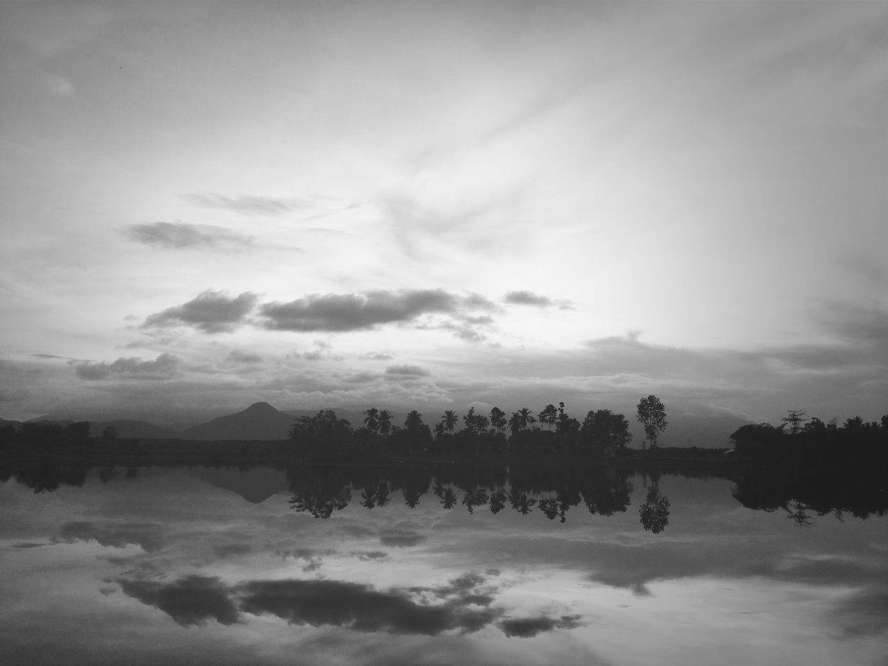 water, reflection, sky, lake, tranquil scene, tranquility, cloud - sky, waterfront, scenics, beauty in nature, nature, cloudy, standing water, cloud, river, calm, idyllic, tree, outdoors, no people