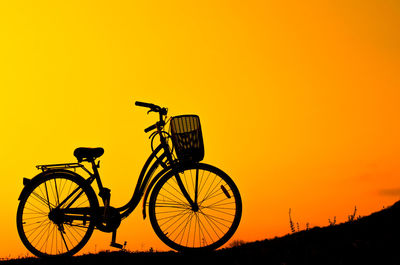 Old bicycle silhouette on a sunset background, close-up