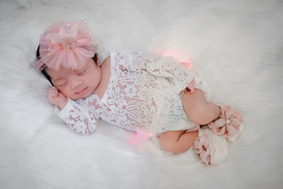 Cute newborn baby sleeps on white fluffy coverlets