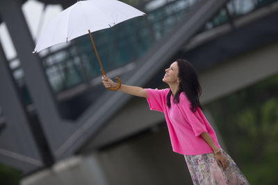Woman holding umbrella standing outdoors