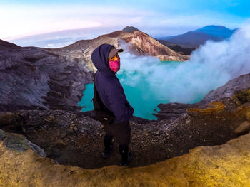 Man standing on rock against mountains