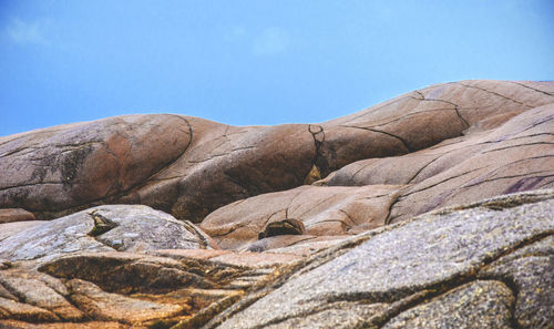 Low angle view of rocky mountain against sky